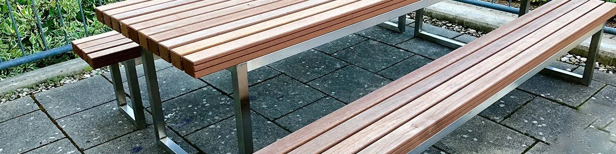 Gartentisch mit Gartenbänken aus Metall und Holz, modern auf Terrasse platziert