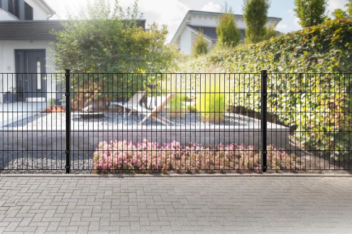 Schwarzer Doppelstabmattenzaun mit Pfosten vor modernem Haus und gepflegtem Vorgarten
