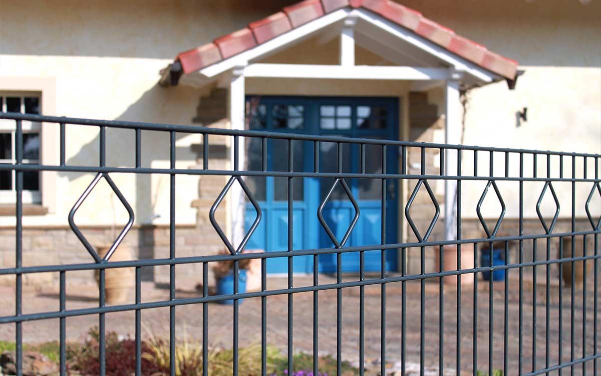 Doppelstabmattenzaun Modell GIRONA mit Rautenmuster vor modernem Eingangsbereich