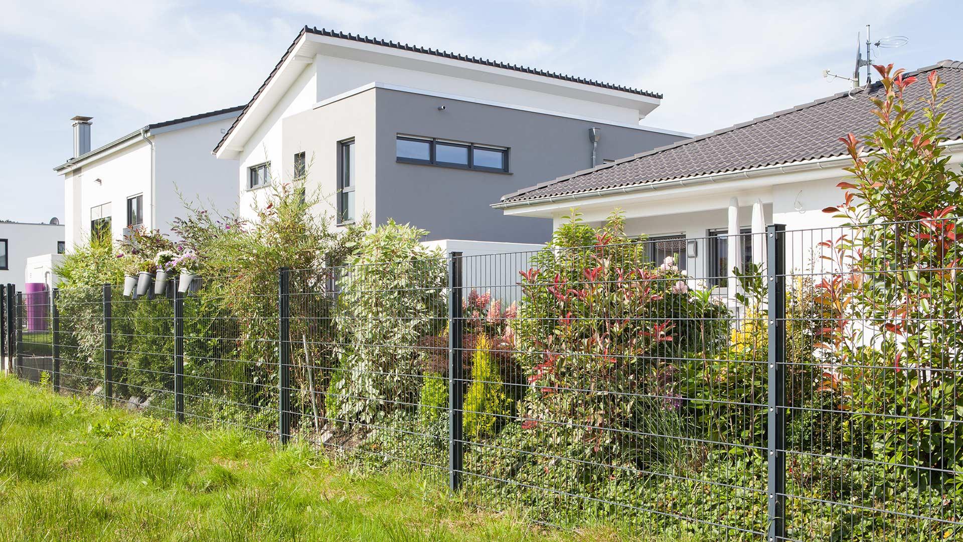 Moderner Doppelstabmattenzaun 6/5/6 vor Einfamilienhaus mit Garten und Bepflanzung