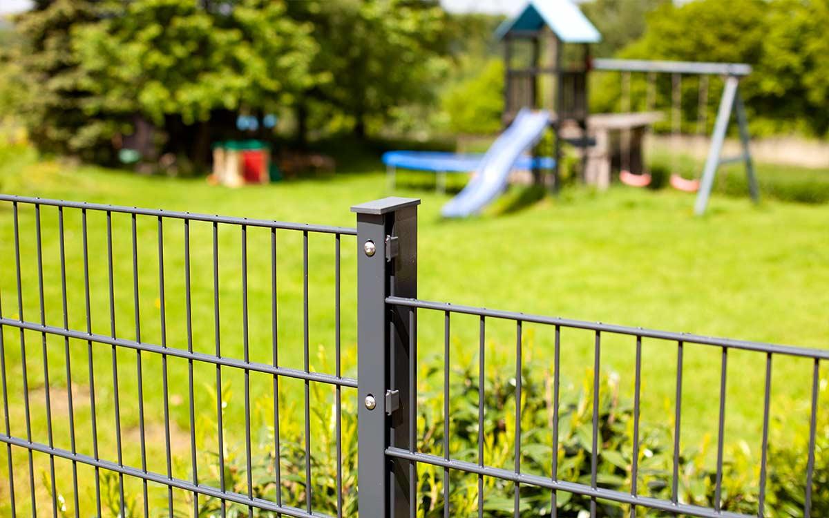 Stabiler Doppelstabmattenzaun aus Metall, Garten mit Spielplatz im Hintergrund