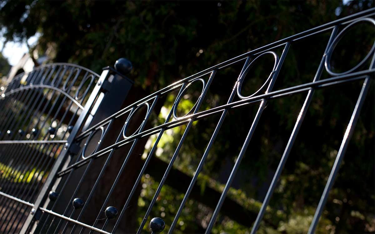 Moderner Doppelstabmattenzaun aus Metall, verziert mit Kreiselementen, im Garten