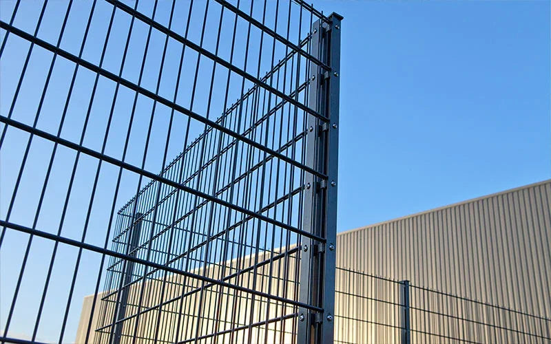 Doppelstabmattenzaun 8/6/8 vor Industriegebäude mit klarem Himmel