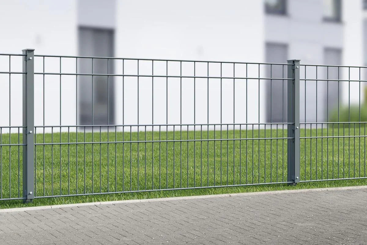 Doppelstabmattenzaun 8/6/8 Modell MILO auf Rasen vor modernem Gebäude