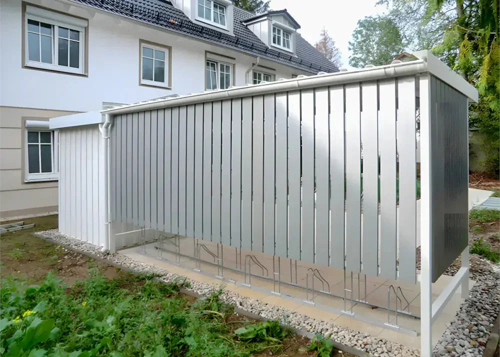 Moderne Fahrradüberdachung aus Metall mit Fahrradständern vor Wohnhaus
