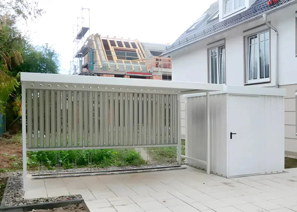 Moderne Fahrradüberdachung aus Metall mit seitlichem Sichtschutz neben Wohnhaus