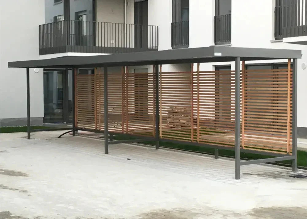 Moderne Fahrradüberdachung aus Metall mit Holzlamellen vor Wohngebäude