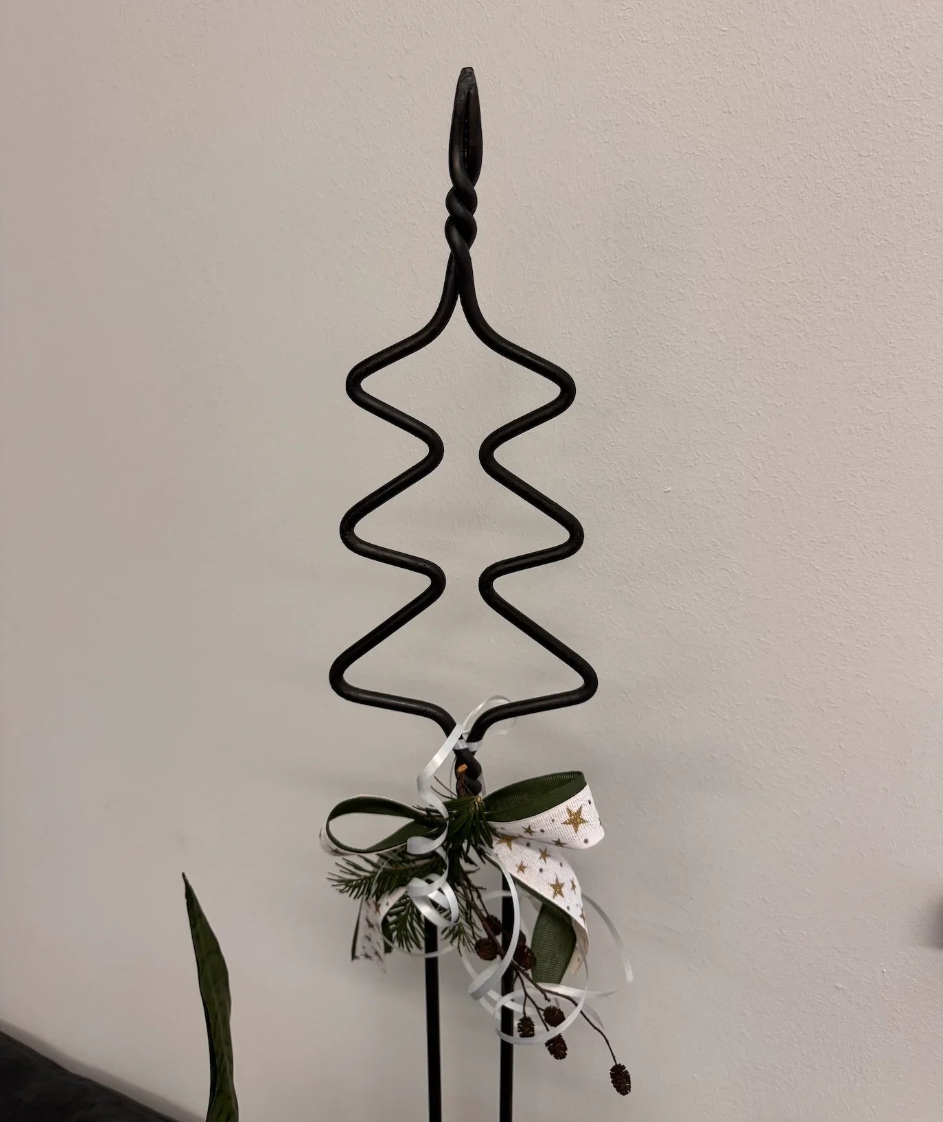 Gartenstab aus Schmiedeeisen in Tannenbaumform mit weihnachtlicher Dekoration, Geschenkband, Zapfen