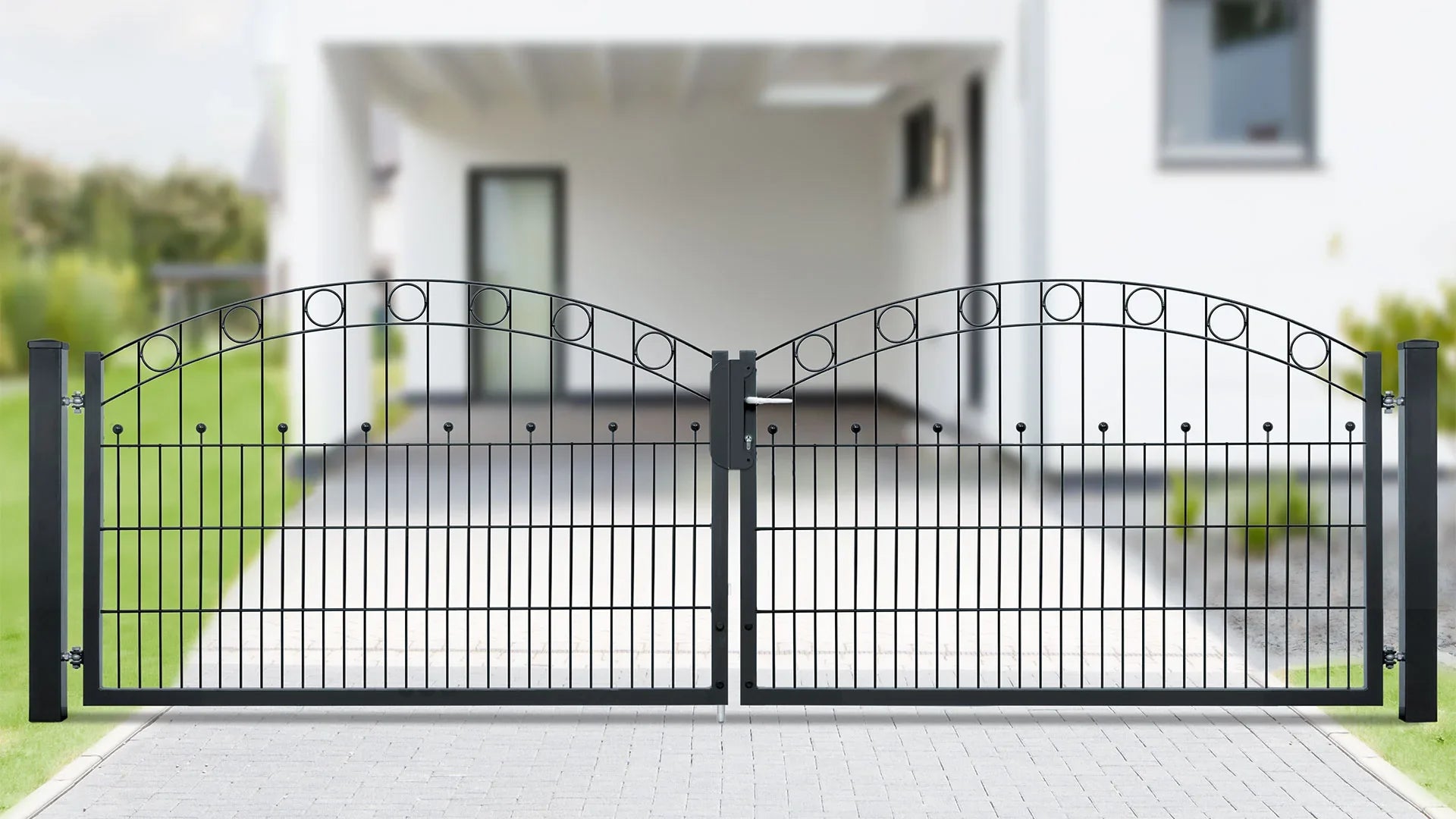 Zweiflügeliges schwarzes Metall Gartentor mit Zierstreben und Kreisen vor modernem Haus