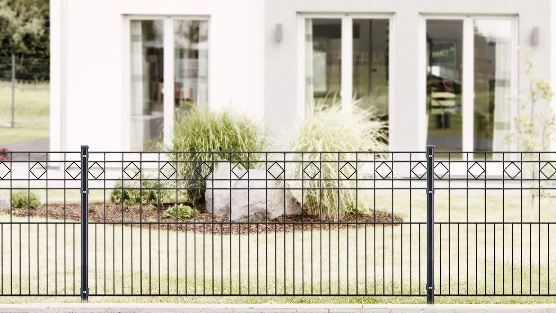 Moderner Metallzaun Modell TURIN vor Haus mit Garten und Ziergräsern, elegante Zaunlösung