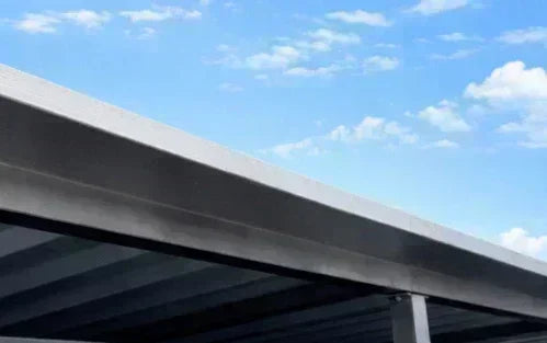 Stirnblech-Verkleidung aus Metall für Trapezblechdach unter blauem Himmel