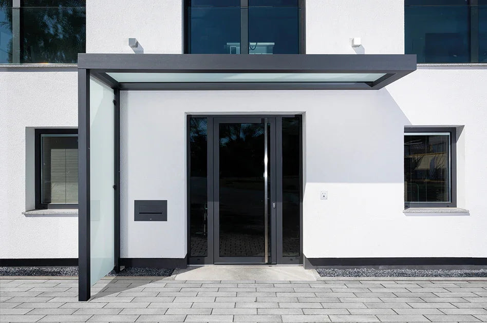 Modernes Vordach aus Glas und Metall an Hauseingang, Seitenwand satiniert, stilvolle Architektur