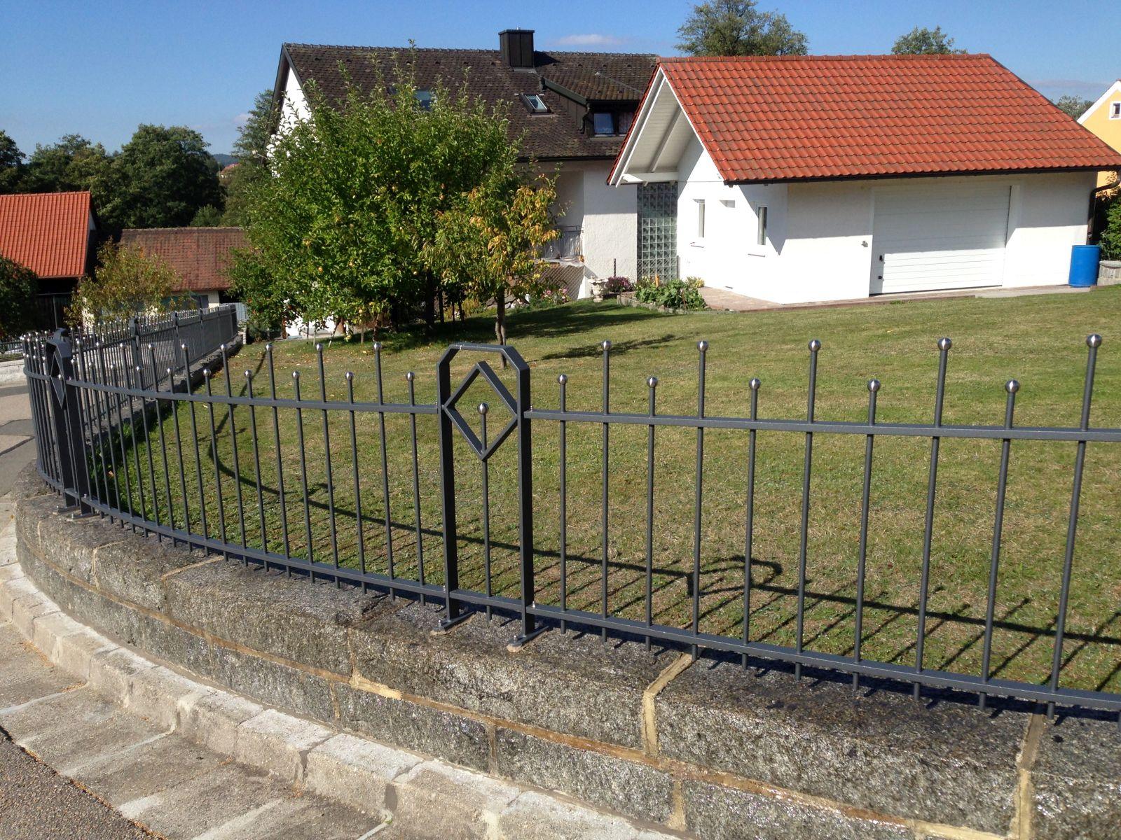 Moderner Metallzaun auf Steinmauer, Vorgarten mit Rasen bei Einfamilienhaus