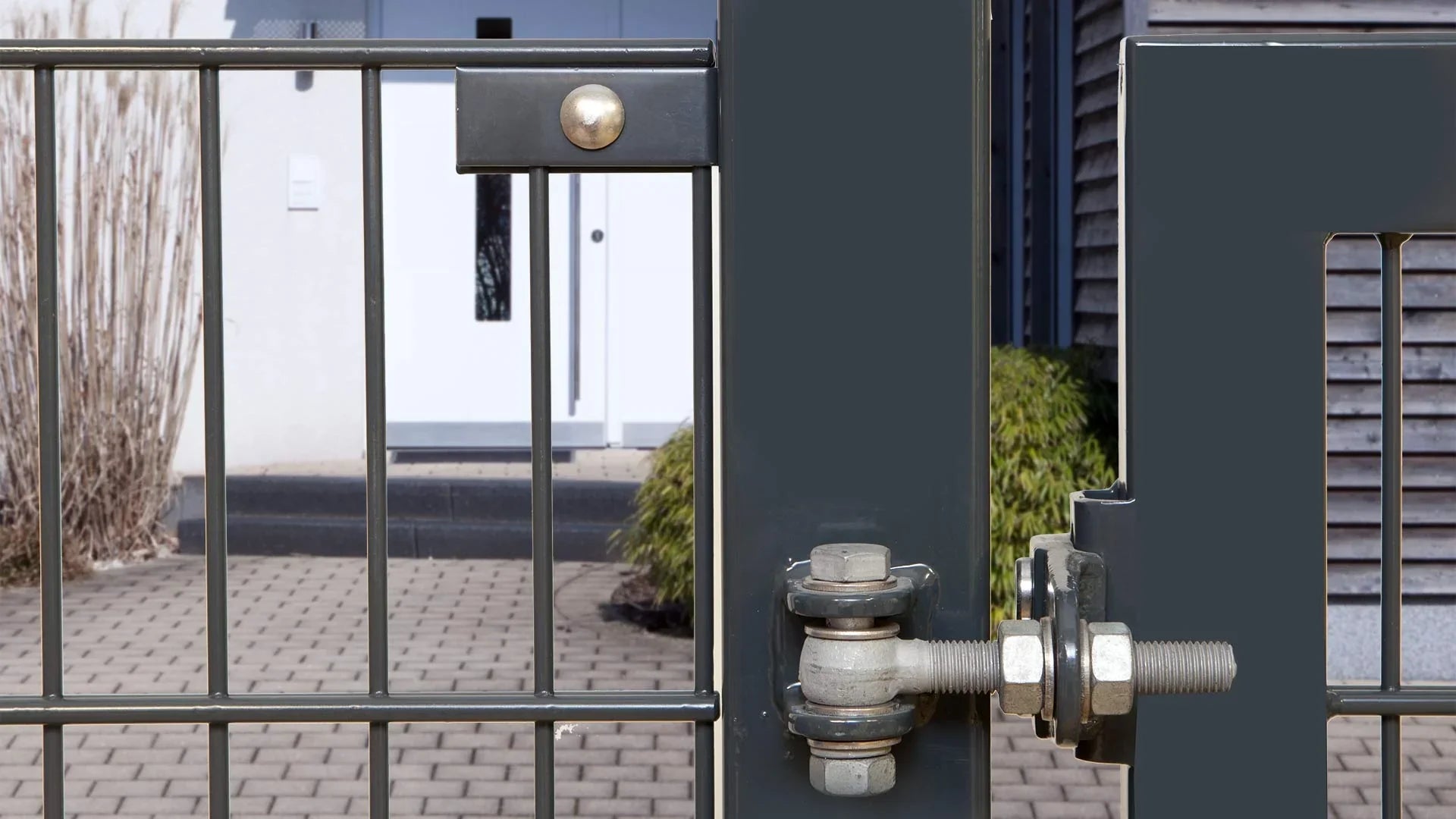 Zaunanschlusswinkel aus Metall, montiert am Gartentor mit Detail der Verschraubung