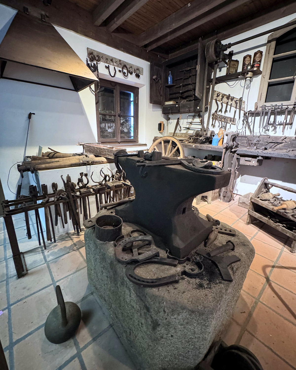 Alte Dorfschmiede mit Amboss auf Granitsockel, Hufeisen, Schmiedezangen und Esse