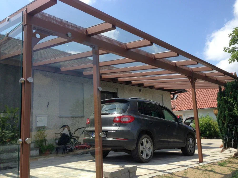 Moderner Carport aus Metall und Glas auf Einfahrt mit geparktem SUV, Haus im Hintergrund