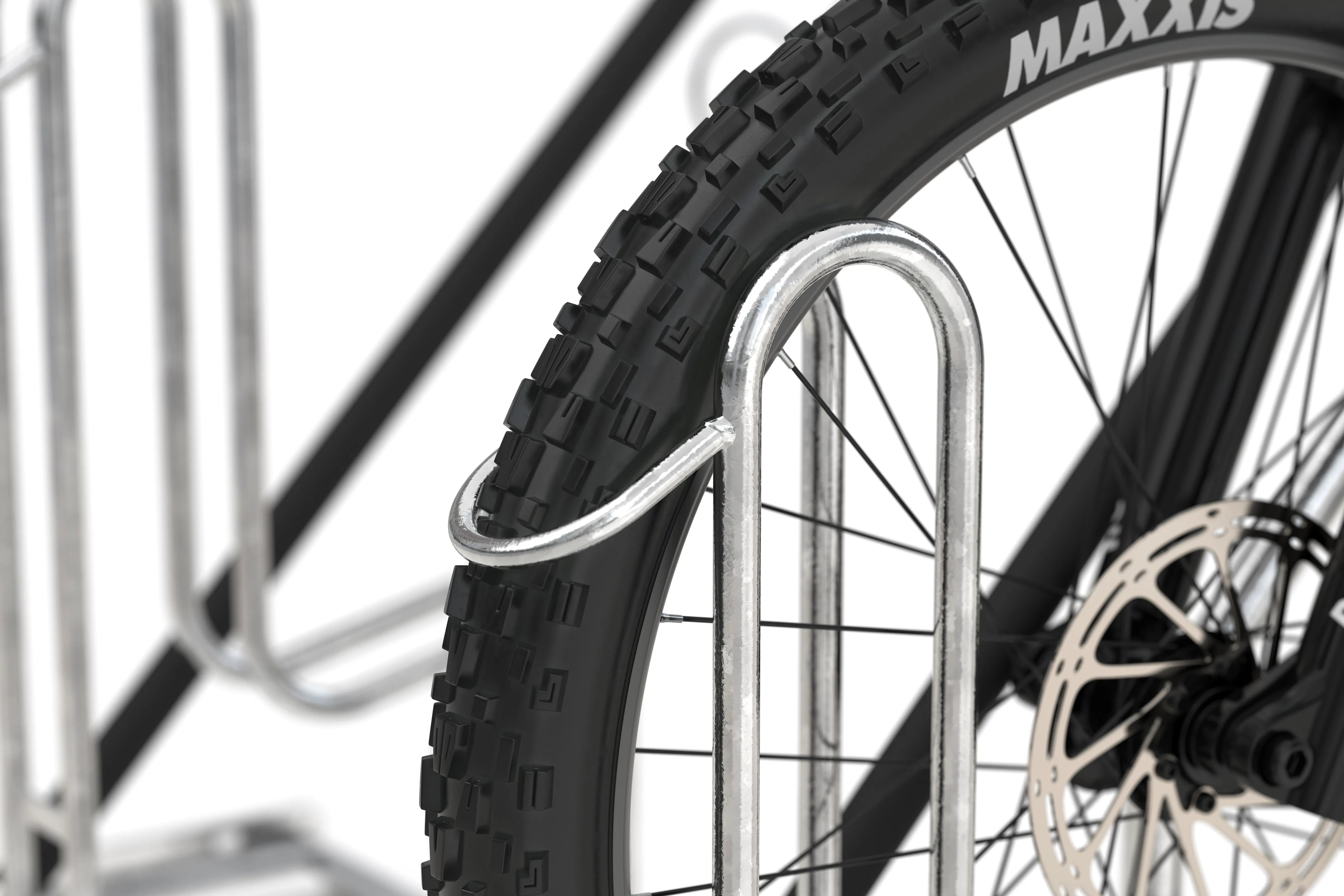 Reifen eines Mountainbikes im verzinkten Fahrradparker, Nahaufnahme von Fahrradständer