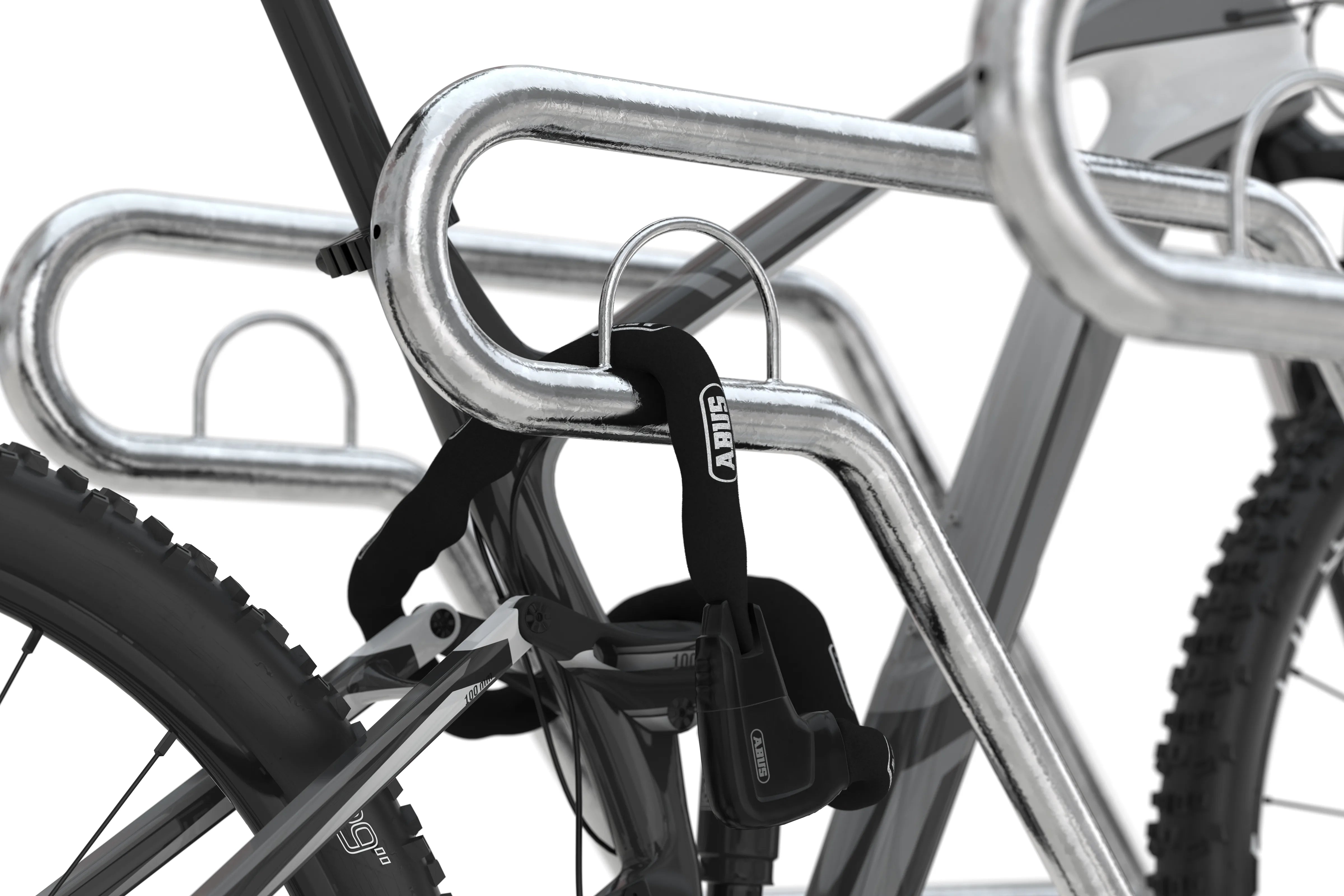Nahaufnahme eines Fahrradständers aus verzinktem Metall mit angeschlossenem Fahrrad und Kettenschloss