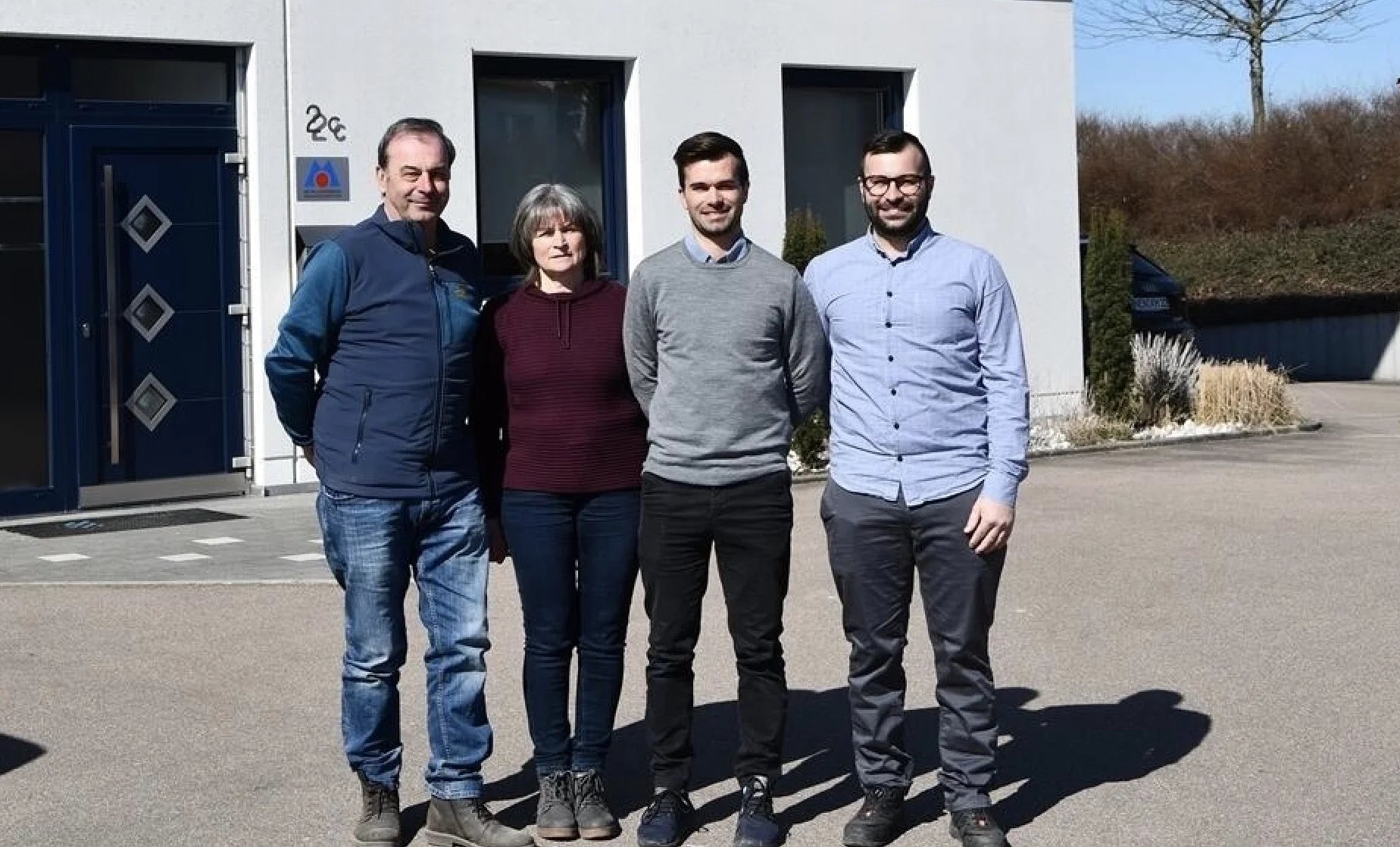 Vier Personen vor Firmengebäude