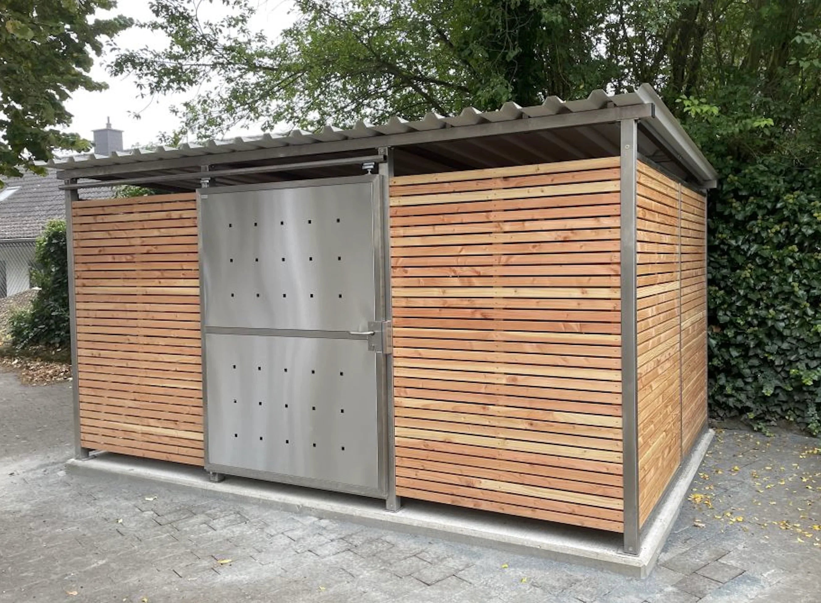 Mülltonnenhaus aus Edelstahl und Holz mit Flachdach, moderner Sichtschutz im Außenbereich