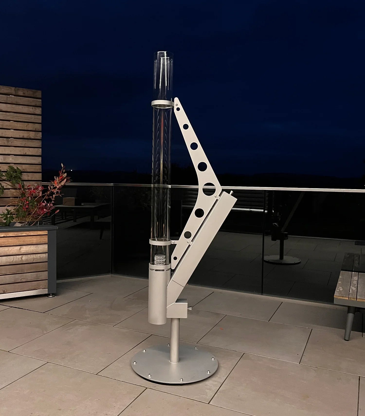 Moderne Pellet Feuersäule Heizpilz aus Metall auf Terrasse bei Nacht