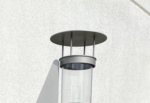 Abdeckung für Pelletfeuer-Feuerrohr aus Edelstahl an heller Wand montiert