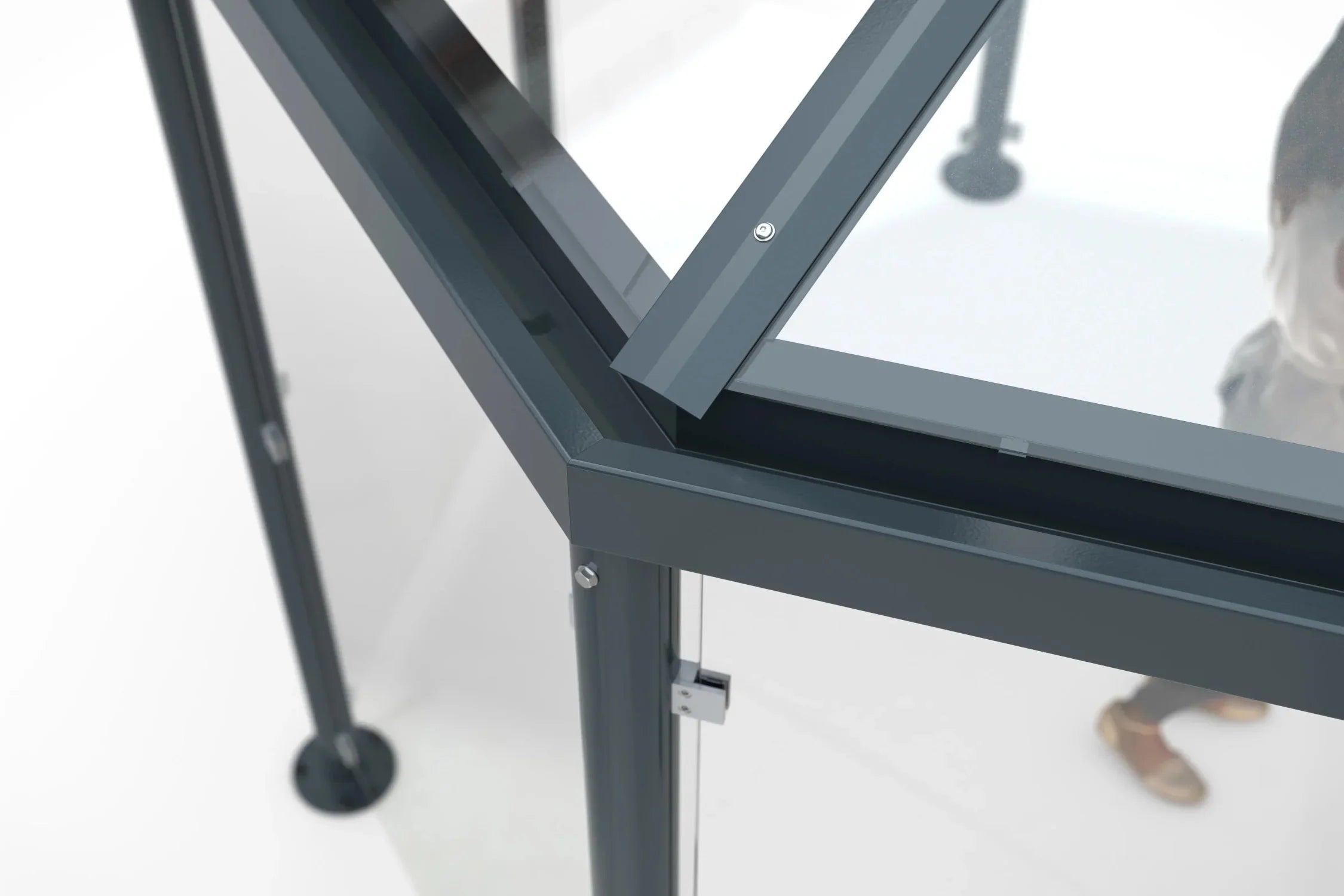 Detail Metallrahmen und Glasdach eines Raucherunterstands, stabile Konstruktion, modern