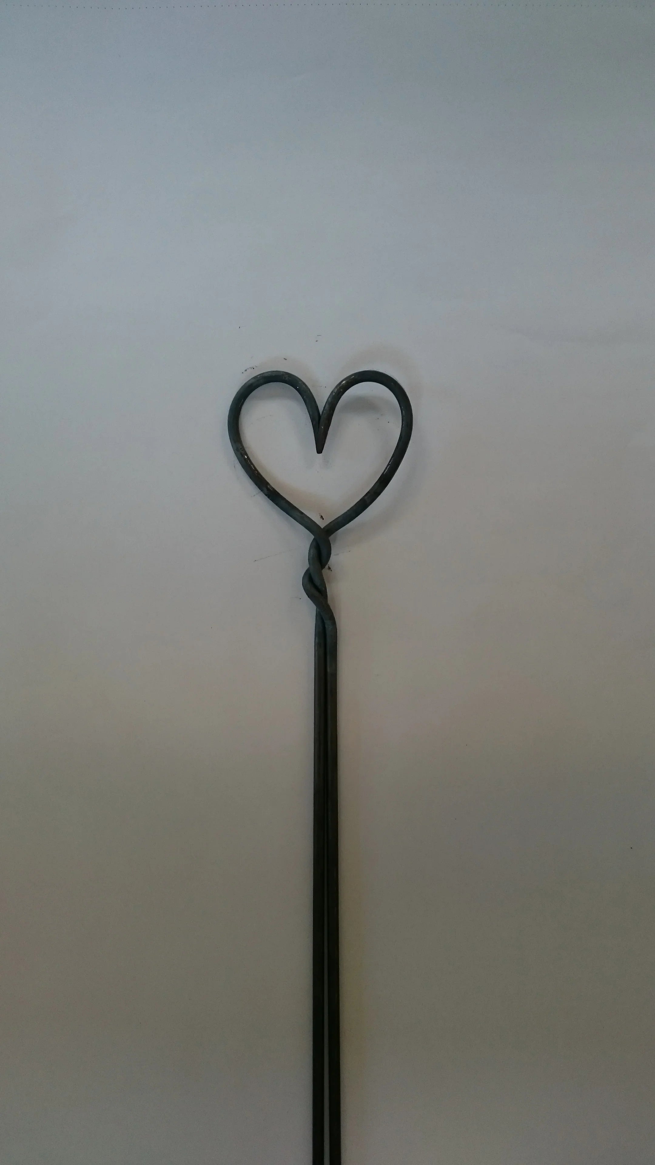Metall Rosenstab in Herzform auf neutralem Hintergrund, dekorativer Gartenstab