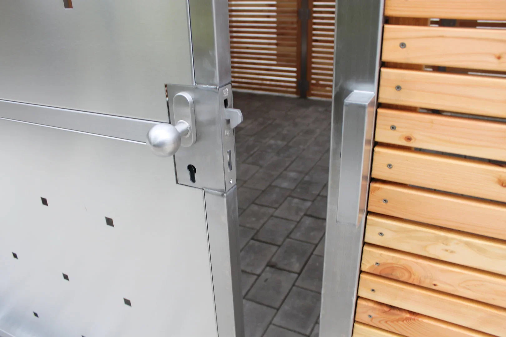 Nahaufnahme einer modernen Schiebetür aus Metall und Holz für Mülltonnenhaus