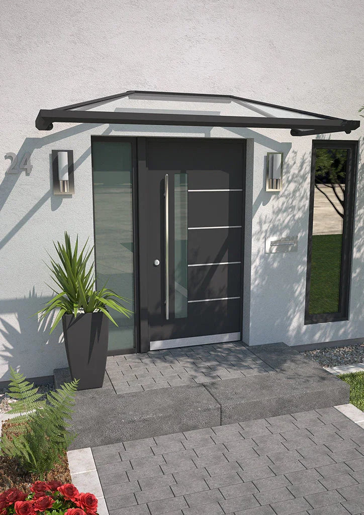 Modernes Vordach aus Aluminium und Glas über einer Haustür, seitlich Pflanze im Topf