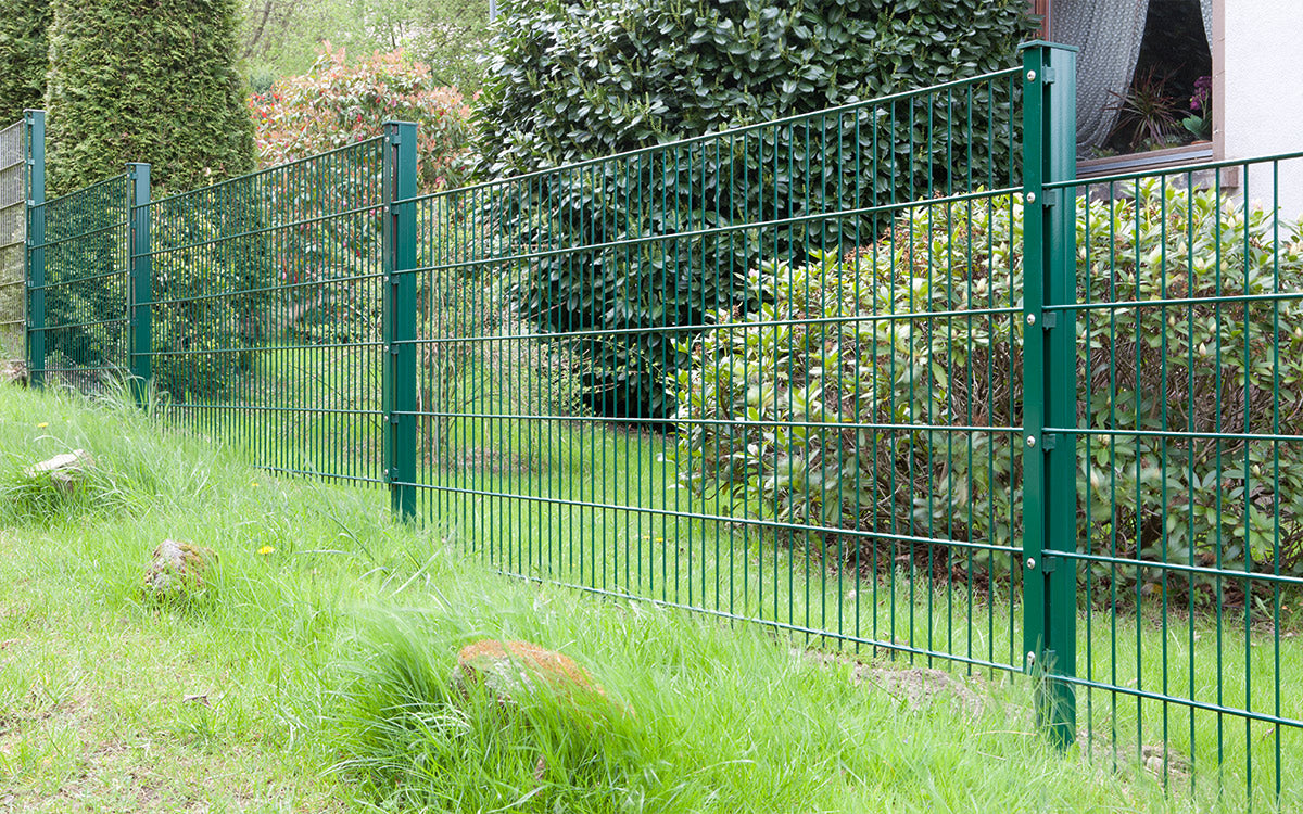 Zaunpfosten Typ A in Moosgrün RAL 6005 an einer Grundstückseinfassung mit Hecke