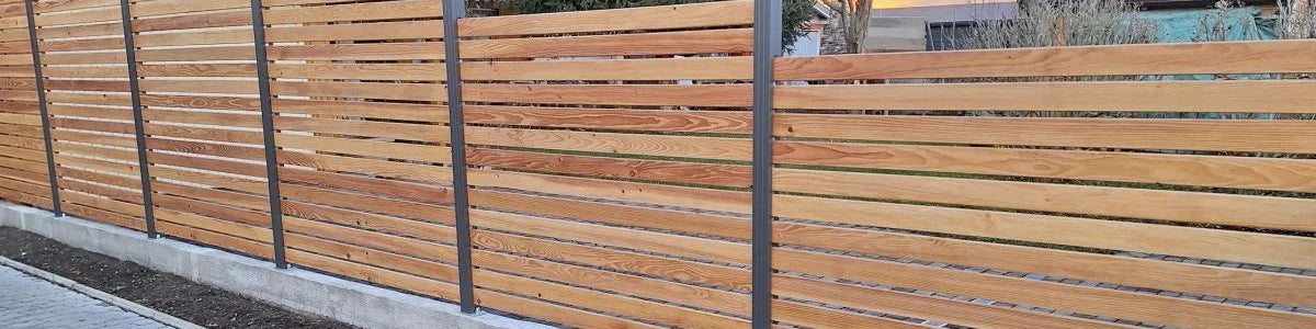 Moderner Sichtschutzzaun aus Holz mit Aluminium Pfosten in einem Wohngebiet