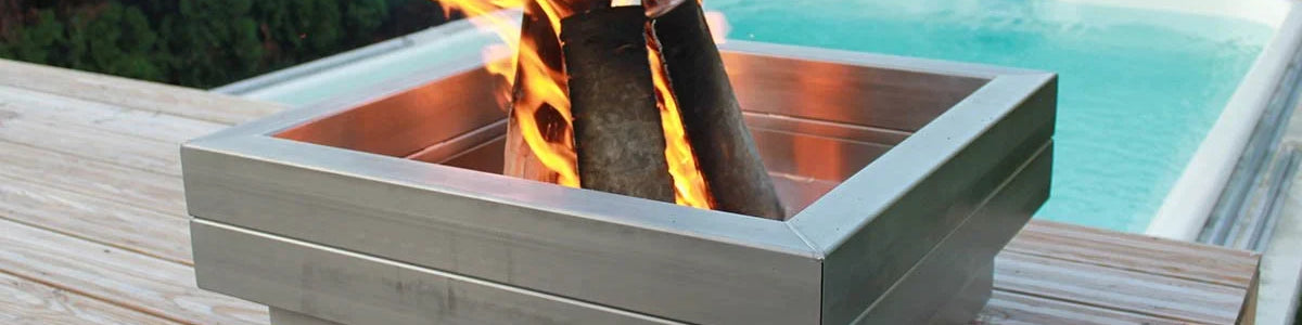 Edelstahl Feuerschale quadratisch mit brennendem Feuer auf Holzterrasse neben Pool
