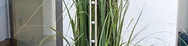 Gartenstab aus Edelstahl mit Herzform vor Ziergras im modernen Außenbereich