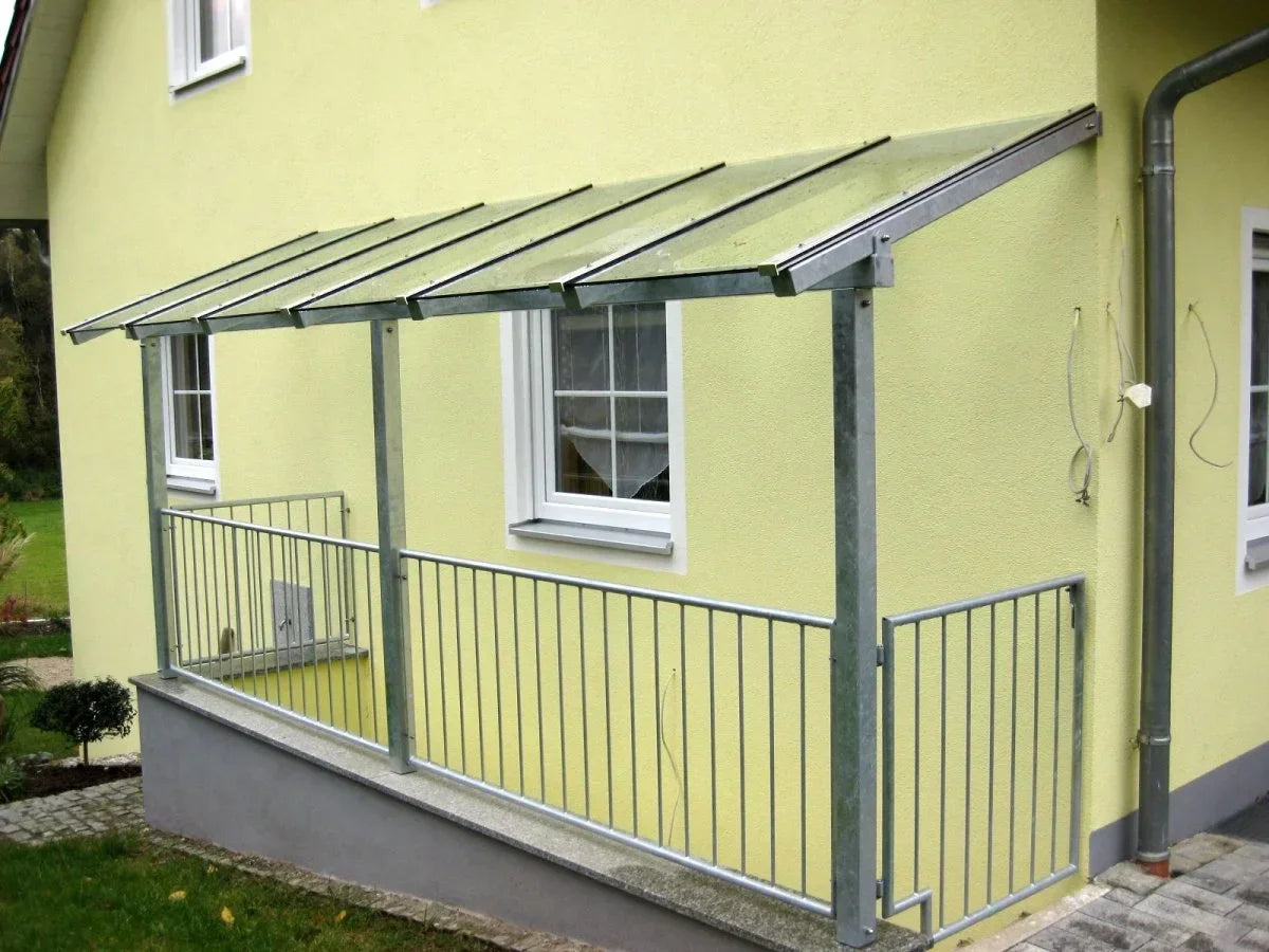 Kellerabgangsüberdachung aus Metall und Glas an gelbem Haus mit Geländer