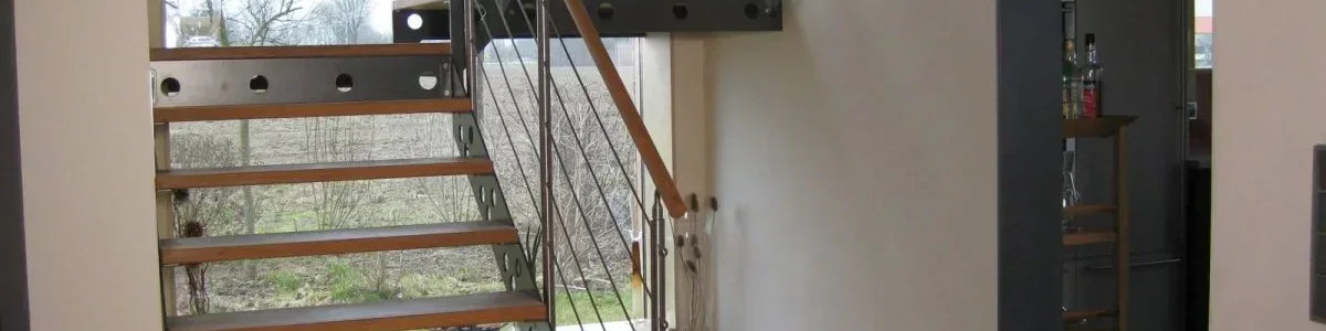 Moderne Innentreppe aus Metall und Holz in einem hellen Wohnraum mit Geländer
