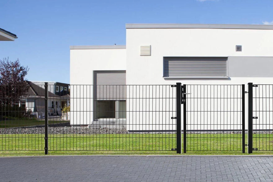 Schwarzer Doppelstabmattenzaun mit Tor vor modernem Haus und grünem Rasen