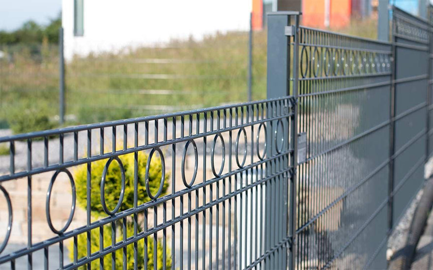 Doppelstabmattenzaun Modell ROM anthrazit mit Dekor-Kreisen im Garten bei Tageslicht