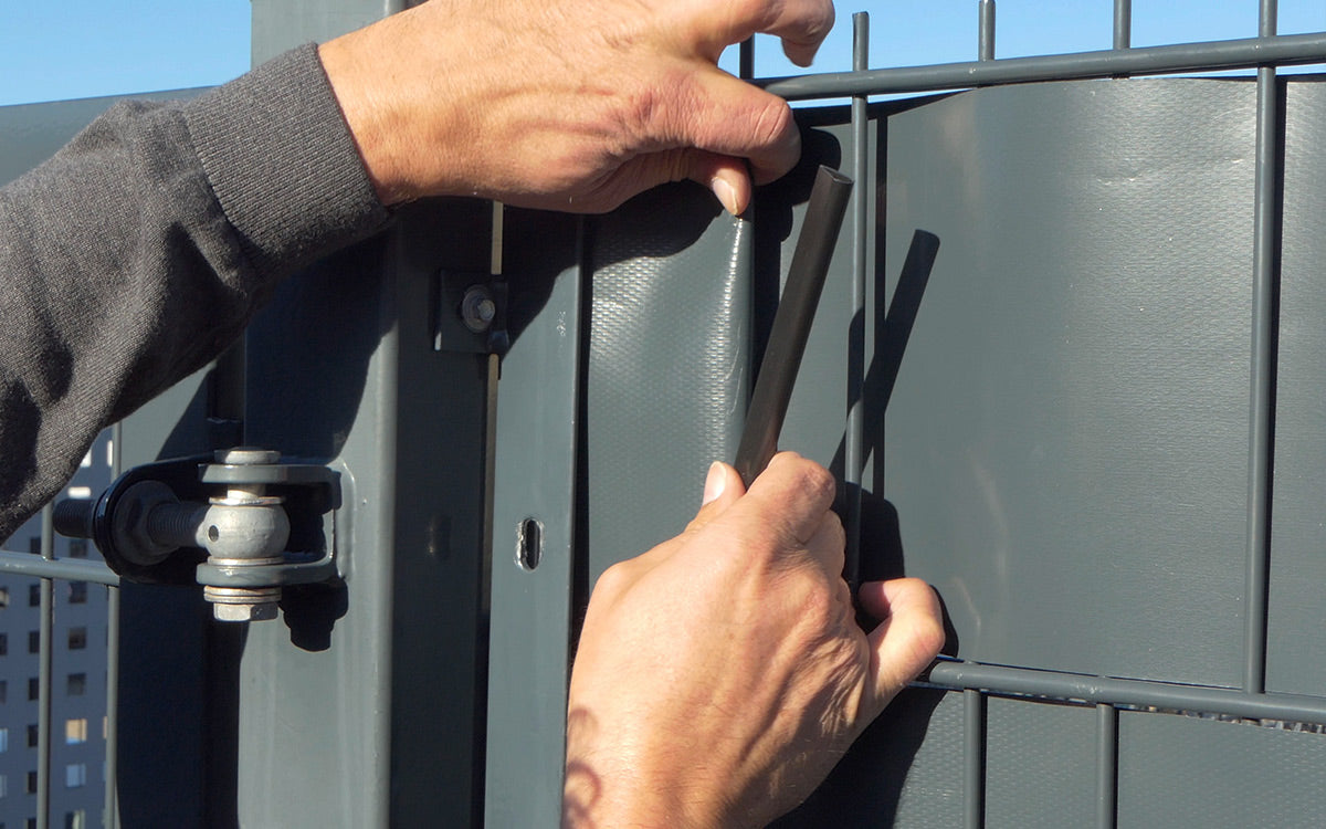 Montage einer Klemmschiene am Doppelstabgitter zur Fixierung des Sichtschutzstreifens