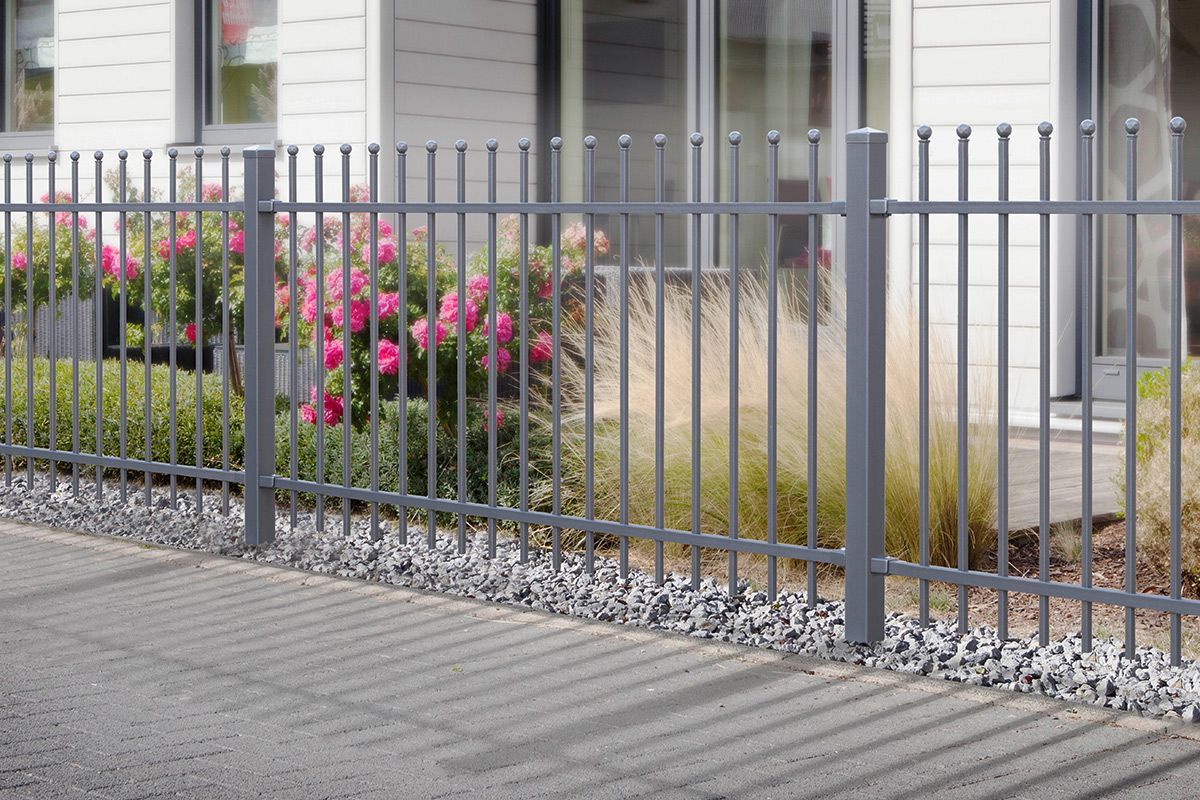 Metallzaun vor modernem Gebäude