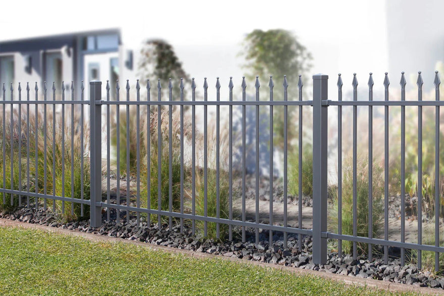 Moderner Metallzaun mit Spitzen im Garten vor einem Wohnhaus, Umzäunung Grundstück
