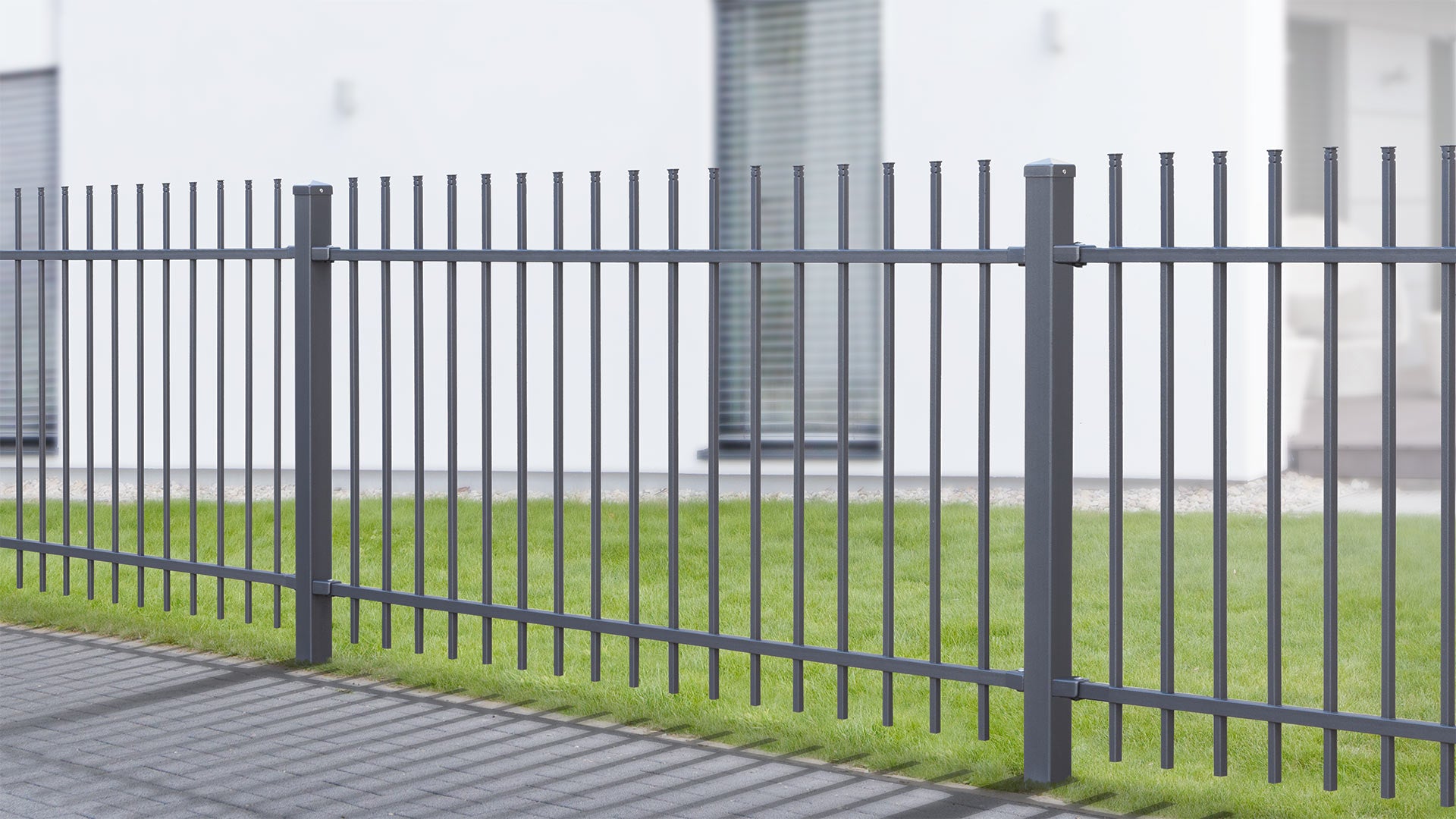 Metallzaun vor modernem Gebäude