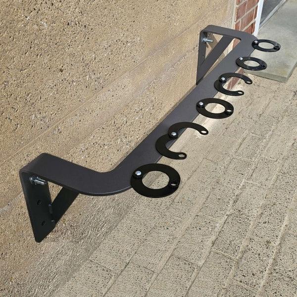 Wandmontierter Scooter-Parkplatz aus Metall an Außenwand, sechs Stellplätze sichtbar