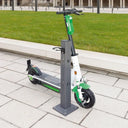 E-Scooter an stabiler Metallsäule mit Halterung auf Gehweg im Außenbereich