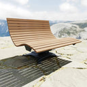 Moderne drehbare Sonnenliege aus Holz und Metall, Outdoor auf Steinboden, Berglandschaft im Hintergrund