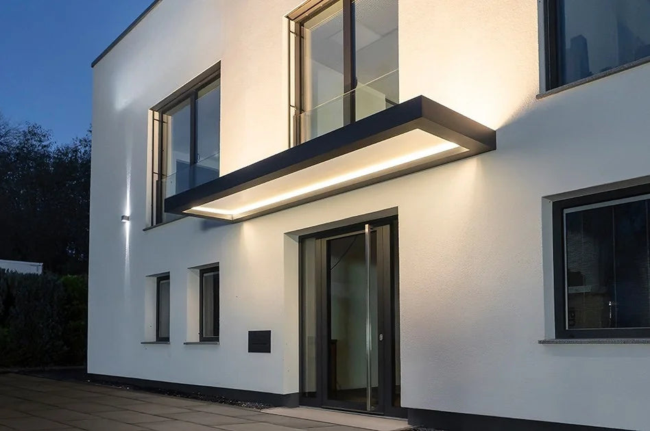 Modernes Vordach aus Glas mit integrierter LED-Beleuchtung an Wohnhaus-Eingang