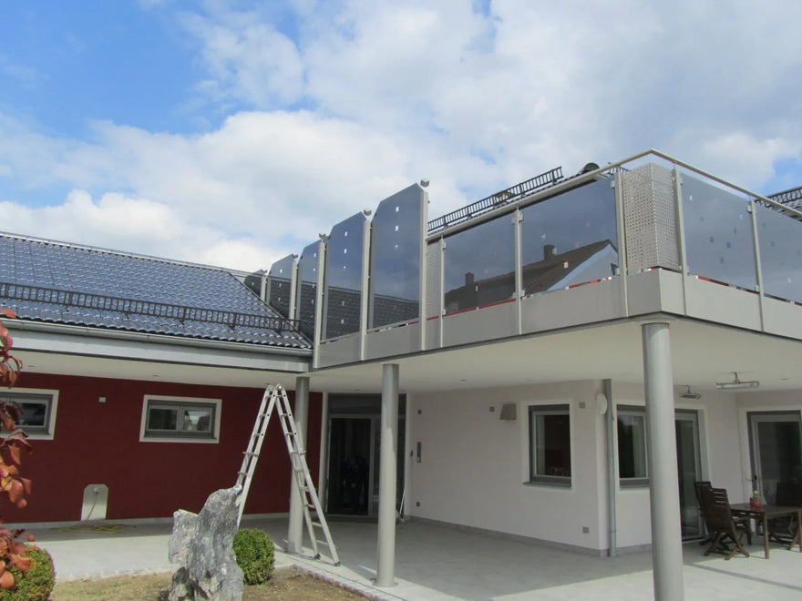 Modernes Balkongeländer aus Glas und Metall an einem Haus mit Terrasse
