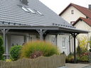 Modernes Metall Carport vor Wohnhaus mit Satteldach und Garten, maßgefertigt