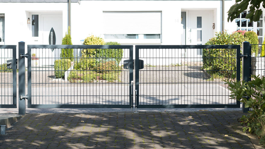 Einfahrtstor VARIO trend vor einem Wohnhaus mit gepflasterter Zufahrt