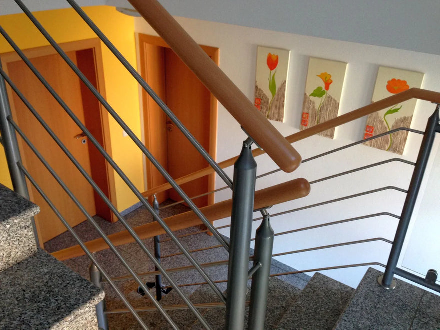 Modernes Metall-Innengeländer mit Holzhandlauf an Granittreppe im Wohnhaus